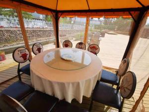 Xindao Xitai Xiaozhu Hotel في Huangkan: طاولة مستديرة مع كراسي وطاولة قماش بيضاء