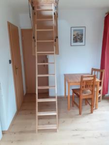 a ladder to the loft bed in a room with a table at Kyprův mlýn in Knínice