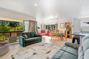 ein Wohnzimmer mit einem Sofa und einem Tisch in der Unterkunft Ota Point Paradise - Whangaroa Holiday Home in Whangaroa