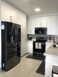 特古西加尔巴JF Three Bedroom Apartment的厨房配有黑色家电和白色橱柜