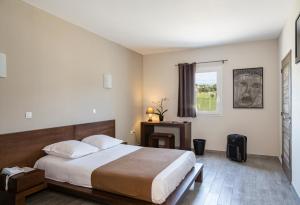 um quarto com uma cama grande e uma janela em Le Ya'Tis em Saint-Laurent-des-Arbres