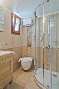 uma casa de banho com um chuveiro, um WC e um lavatório. em Olive Studios Karpathos Studio #4 em Cárpatos