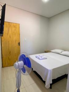 a bedroom with a fan next to a bed at Hotel Pousada Aeroporto in Ponta Porã