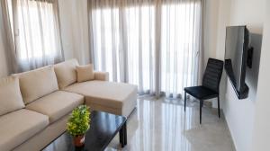 a living room with a white couch and a chair at Mythic Villas in Epanomi