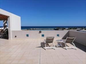 un patio con sillas y una mesa en el techo en Le Sifah - Marina View Apartments & Villa en As Sīfah