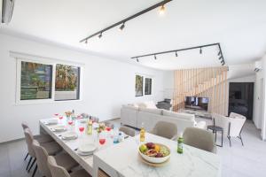 a dining room and living room with a table and chairs at Kube Luxury Villas in Ayia Napa