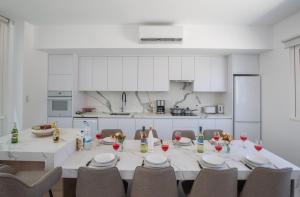 a large white kitchen with a table and chairs at Kube Luxury Villas in Ayia Napa