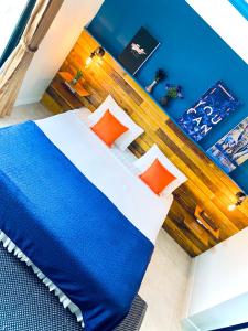 um quarto com uma cama com almofadas azuis e laranja em BH Baan Paradise Hotel em Patong Beach