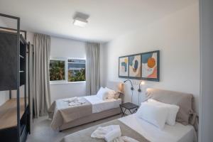 a hotel room with two beds and a television at Kube Luxury Villas in Ayia Napa +37 photos