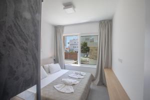 a bedroom with a bed and a large window at Kube Luxury Villas in Ayia Napa