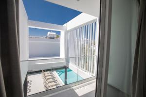 a room with a balcony with a view of the ocean at Kube Luxury Villas in Ayia Napa