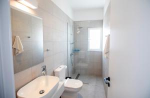 a white bathroom with a toilet and a sink at Kube Luxury Villas in Ayia Napa