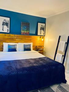 a bedroom with a large bed with blue walls at BE Baan Paradise Hotel in Patong Beach