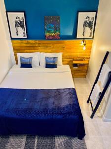a bedroom with a large bed with a blue wall at BE Baan Paradise Hotel in Patong Beach