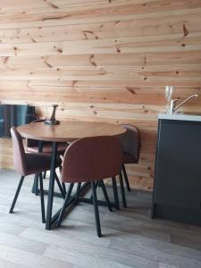 a wooden table and chairs in a room with a wooden wall at Arranmore Glamping in Aphort