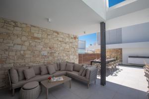 a living room with a couch and a stone wall at Kube Luxury Villas in Ayia Napa