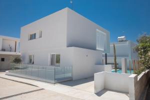 a white house with a glass facade at Kube Luxury Villas in Ayia Napa