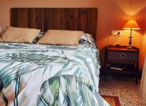 a bedroom with a bed and a table with a lamp at Cal Baster in Vallbona de les Monges