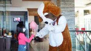 une fille tenant une personne en costume d'ours tenant un ballon dans l'établissement Swiss-Belhotel Balikpapan, à Balikpapan