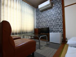 Zimmer mit Sofa, Tisch und TV in der Unterkunft Kinoie - Vacation STAY 19748v in Toyooka