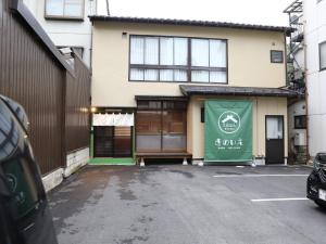 un edificio con una puerta verde en un aparcamiento en Kinoie - Vacation STAY 19748v, en Toyooka