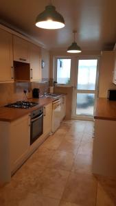 a kitchen with white appliances and a large window at Bader House in Aberporth