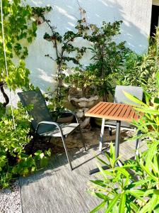 een terras met een tafel, stoelen en planten bij Les Pinsons studio in La Ciotat