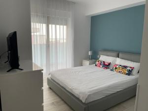 1 dormitorio con 1 cama y TV de pantalla plana en Vela Luxury Sea View Apartments - Marina Surf, en Mamaia Nord – Năvodari