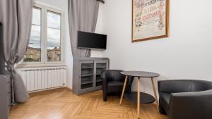 een woonkamer met een tafel en stoelen en een televisie bij Apartments ART TEATRO in Rijeka