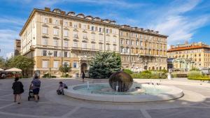 een groot gebouw met een fontein voor een gebouw bij Apartments ART TEATRO in Rijeka