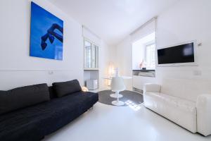 ein Wohnzimmer mit einem schwarzen Sofa und einem TV in der Unterkunft PM3 Apartment in Neapel