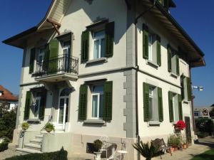a white house with green shutters on it at Zimmer Solothurn Doppelbett in Luterbach