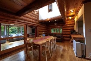 小谷村的住宿－太陽雪木屋度假屋，一间带木桌和椅子的用餐室