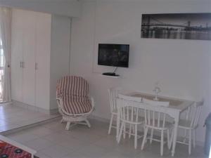 a kitchen with a table and chairs and a television at Camarque 28 in Umdloti