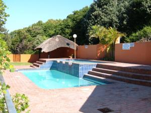 a swimming pool in a yard with stairs at Camarque 28 in Umdloti