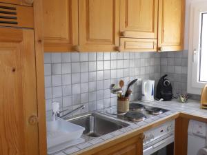 a kitchen with a sink and a counter top at Apartment in Disentis with Garden BBQ Mountain Views in Disentis