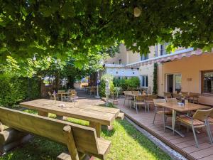 an outdoor patio with wooden tables and chairs at AKZENT Hotel Landgasthof Murrer in Straubing