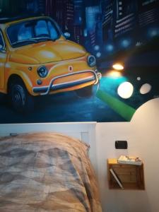 ein Schlafzimmer mit einem Gemälde eines Autos an der Wand in der Unterkunft B&B Borgo Vanchiglia in Turin