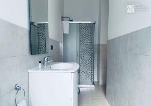 a white bathroom with a sink and a shower at Traiano 28 in Turin