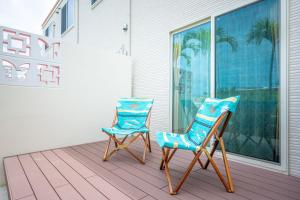 two chairs sitting on the porch of a house at Palm Springs Miyakojima Resort in Miyako Island