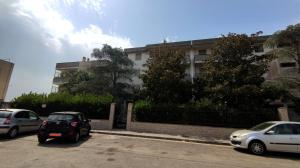 dos autos estacionados en un estacionamiento frente a un edificio en Casa di Gigi- comodo appartamento in Galatina, en Galatina