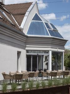 a group of chairs and tables in front of a house at Hotel Bestseller in Kecskem&eacute;t