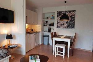 eine kleine Küche und ein Esszimmer mit einem Tisch und Stühlen in der Unterkunft L'Appart de La Baule, piscines , proche mer. in La Baule