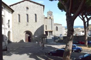 a large stone church with a clock tower and a car at Palazzo Grandori Alloggi Turistici in Viterbo