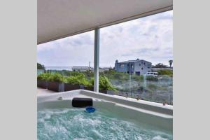 a jacuzzi tub with a view of a house at Beach & Mountain Retreat within a UNESCO Biosphere in Rooiels