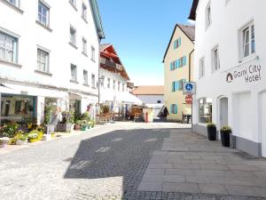 a cobblestone street in a town with white buildings at Garni City Hotel in Füssen