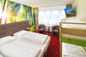 ein Hotelzimmer mit zwei Betten und einem Tisch in der Unterkunft AHORN Panorama Hotel Oberhof in Oberhof