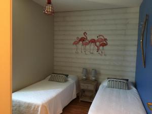 a room with two beds with flamingos on the wall at LADOREPONTAISE in Pondaurat