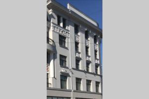 Un edificio blanco con un cartel al costado. en Flamingo apartment (FA), en Riga