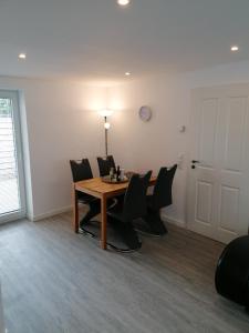 a dining room with a wooden table and chairs at Sharky Ferienwohnung in Bahnhofsnähe in Niebüll